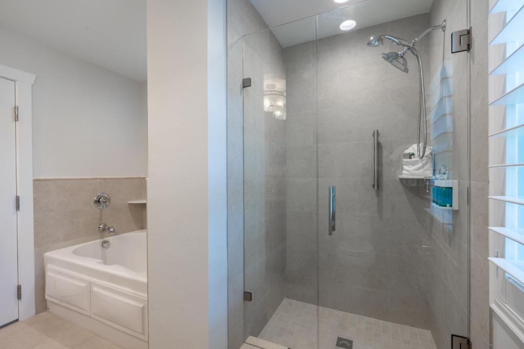 a bathroom with a shower and a tub and a sink at Islander Resort in Islamorada