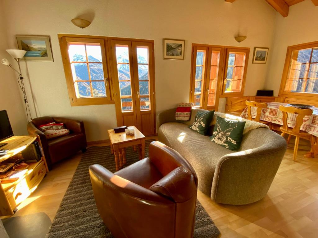 sala de estar con sofá, sillas y mesa en Chalet Amos en Grimentz