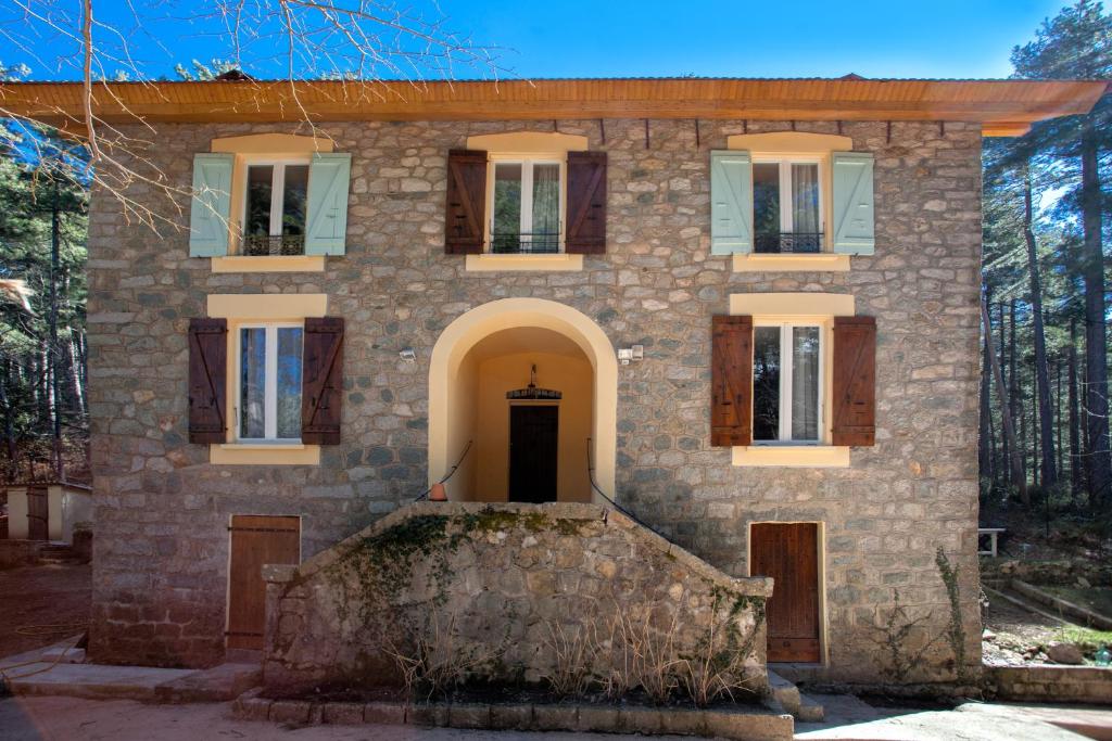 uma antiga casa de pedra com uma porta e janelas em Casa Alta em Vizzavona