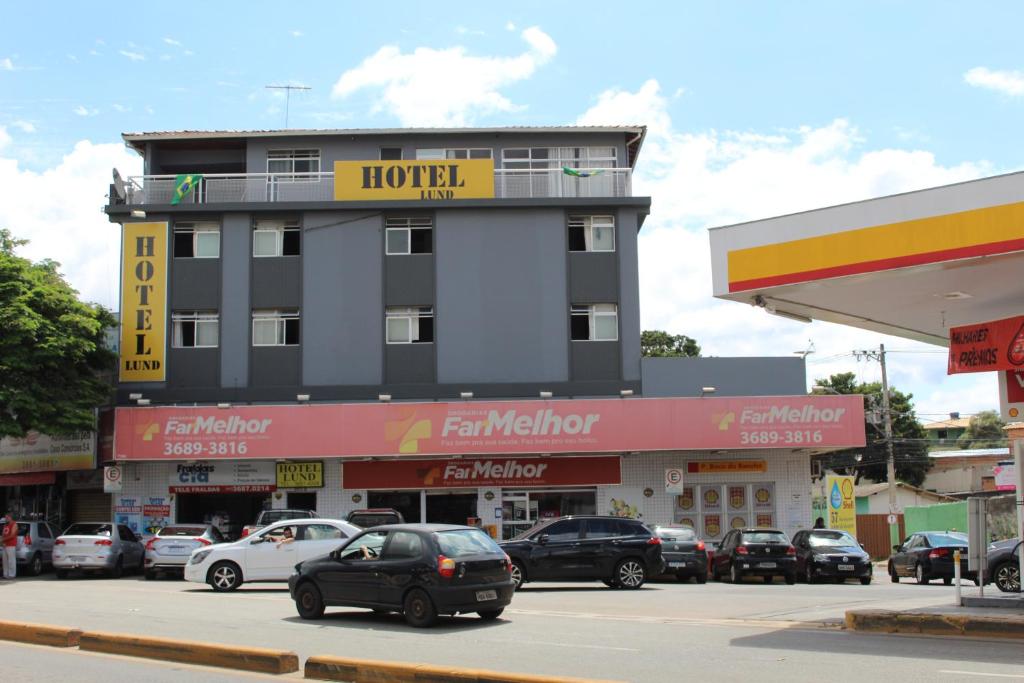 um hotel com carros estacionados em frente a um parque de estacionamento em Hotel Lund em Lagoa Santa