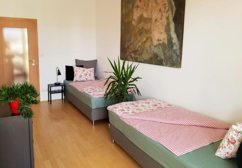 a room with two beds and a painting on the wall at New Pest Apartman in Budapest