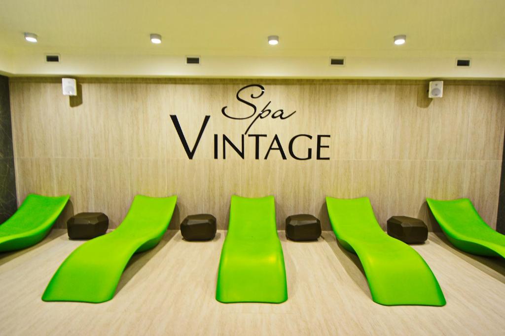 a conference room with green chairs and a sign at Spa Hotel "VINTAGE" in Anapa