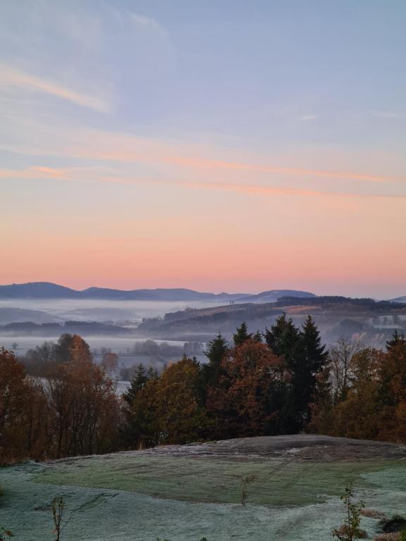 vista para um vale nevoeiro ao pôr-do-sol em Ferienwohnung Hennemann em Schmallenberg