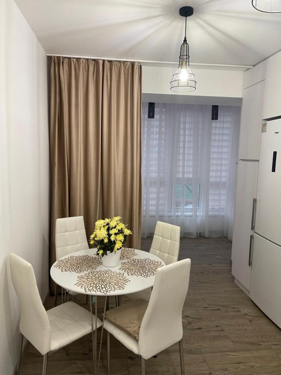 una sala da pranzo con tavolo e sedie bianche di V&G Apartment a Lviv