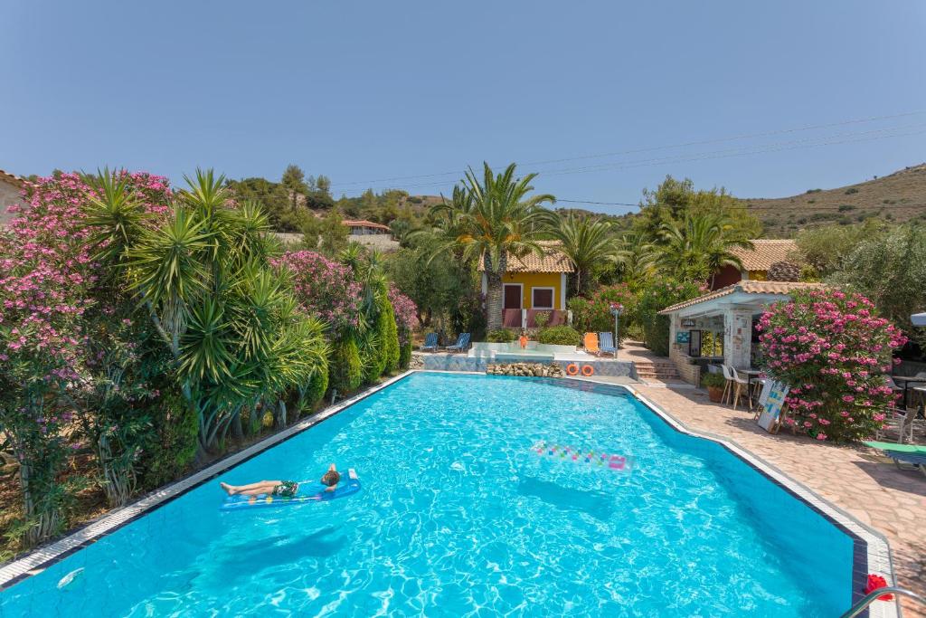 a swimming pool with two people in the water at Garden of Eden in Kalamaki