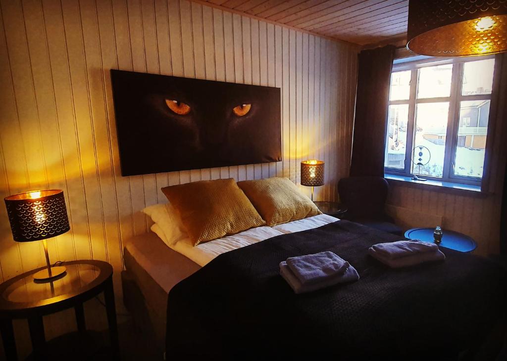 a bedroom with a bed with a cat head on the wall at Nyksund Ekspedisjonen in Nyksund