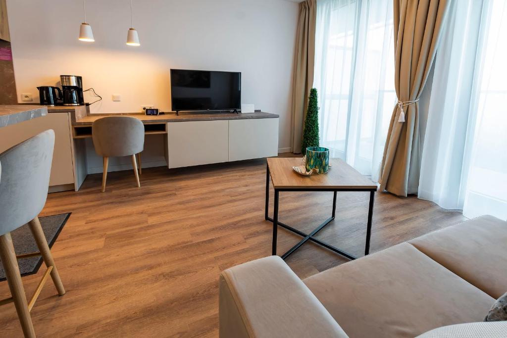 a living room with a couch and a table at VacationClub – Jantaris Apartament A24 in Mielno