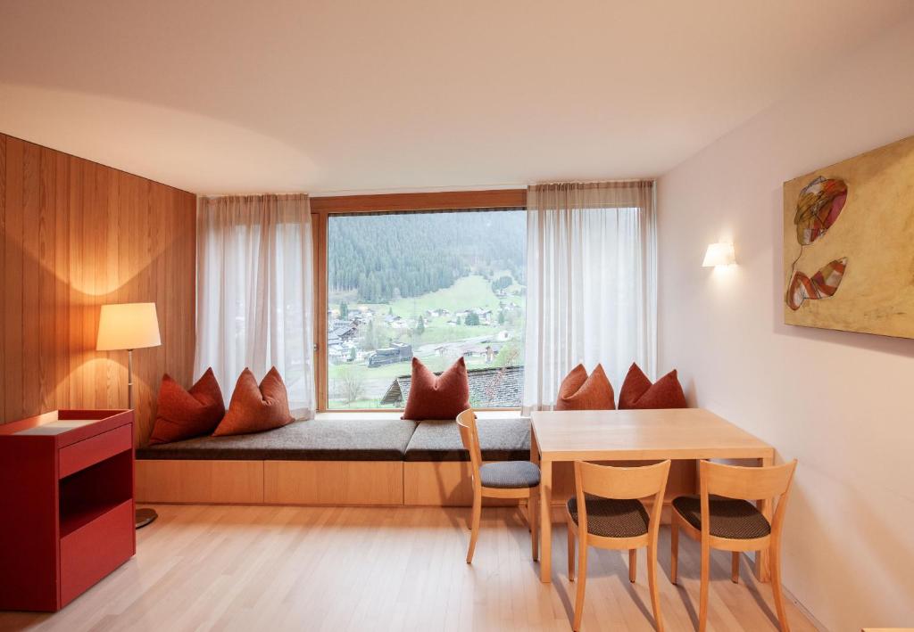 a room with a table and a bed with a window at Bonawinkel NEU in Gaschurn