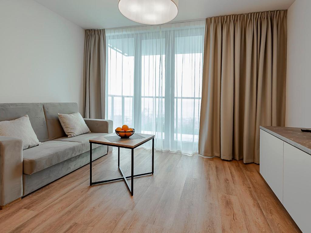 sala de estar con sofá y mesa en VacationClub – Jantaris Apartament B34 en Mielno