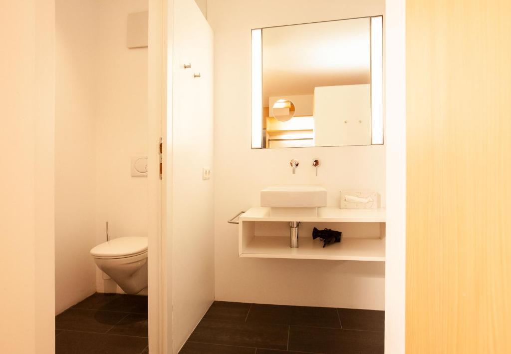 a bathroom with a toilet and a sink and a mirror at Bonawinkel NEU in Gaschurn