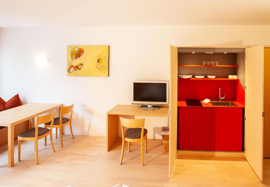 a dining room with a table and a red cabinet at Bonawinkel NEU in Gaschurn