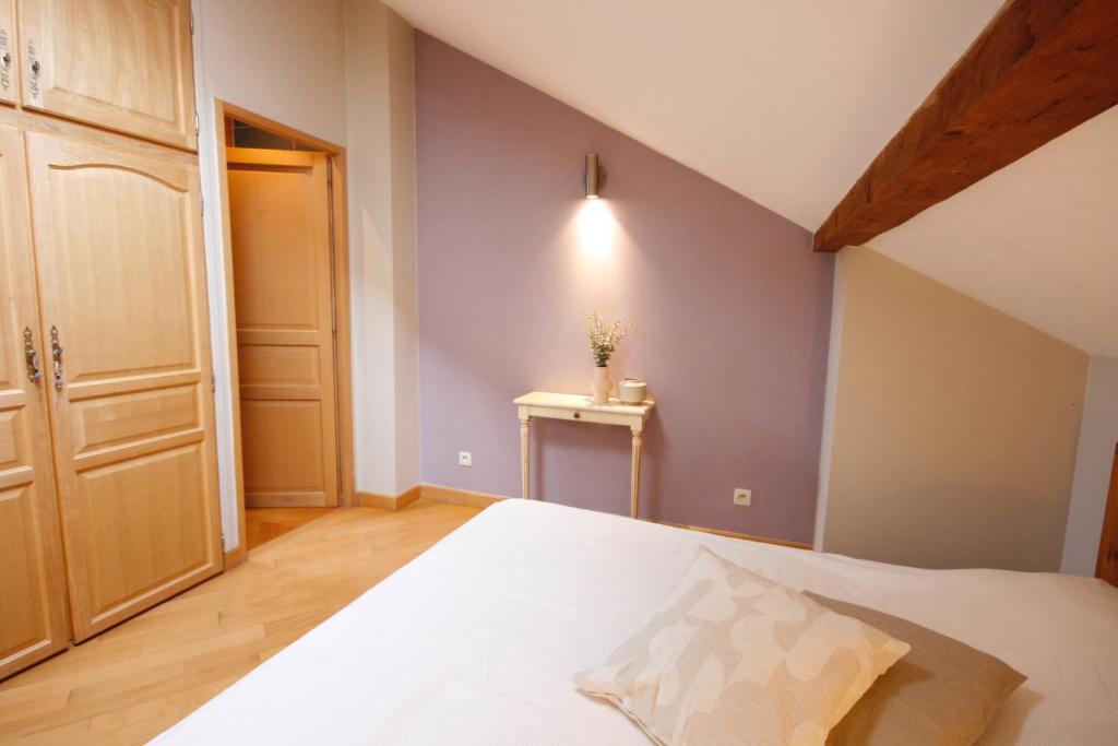 a bedroom with a large white bed and a table at Appartement Rapp in Colmar