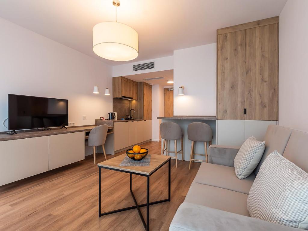 a living room and kitchen with a couch and a table at VacationClub – Jantaris Apartament B35 in Mielno