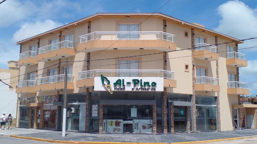 a large building with a store in front of it at Apartamentos Mykonos in Las Toninas