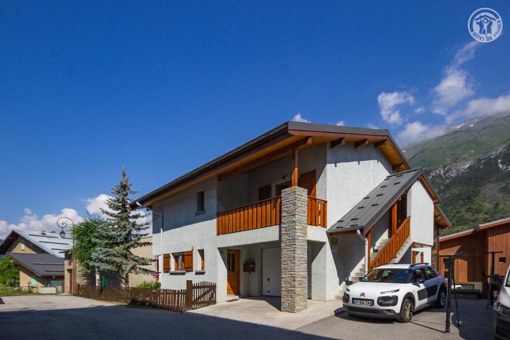 a white car parked in front of a house at La Tomba Val-Cenis Lanslevillard in Lanslevillard