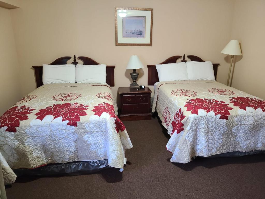 um quarto de hotel com duas camas e duas lâmpadas em Clarysville Motel em Frostburg
