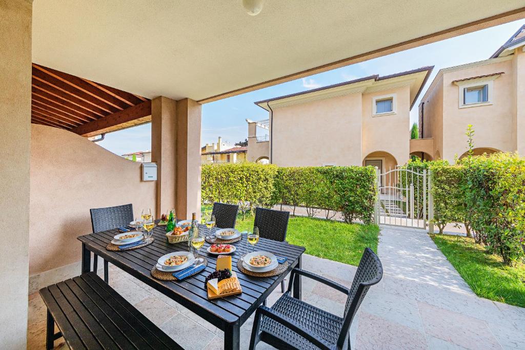 a table with food on it on a patio at La Romantica Holiday Homes by Wonderful Italy in Manerba del Garda