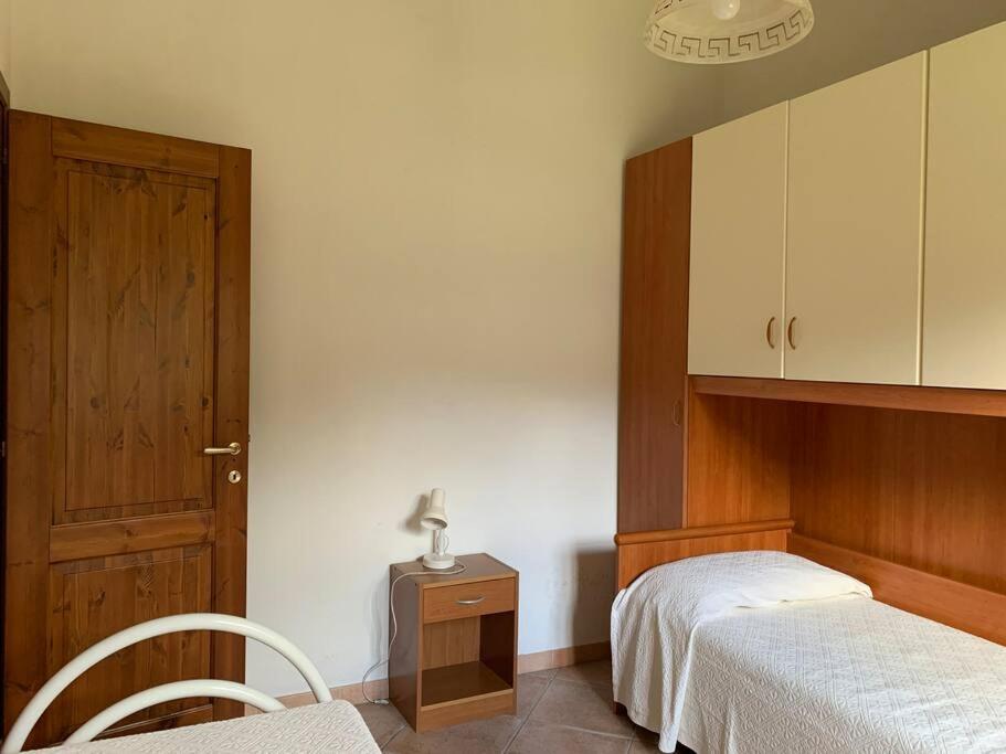 a bedroom with two beds and a wooden door at Villa Magnolia in Chia
