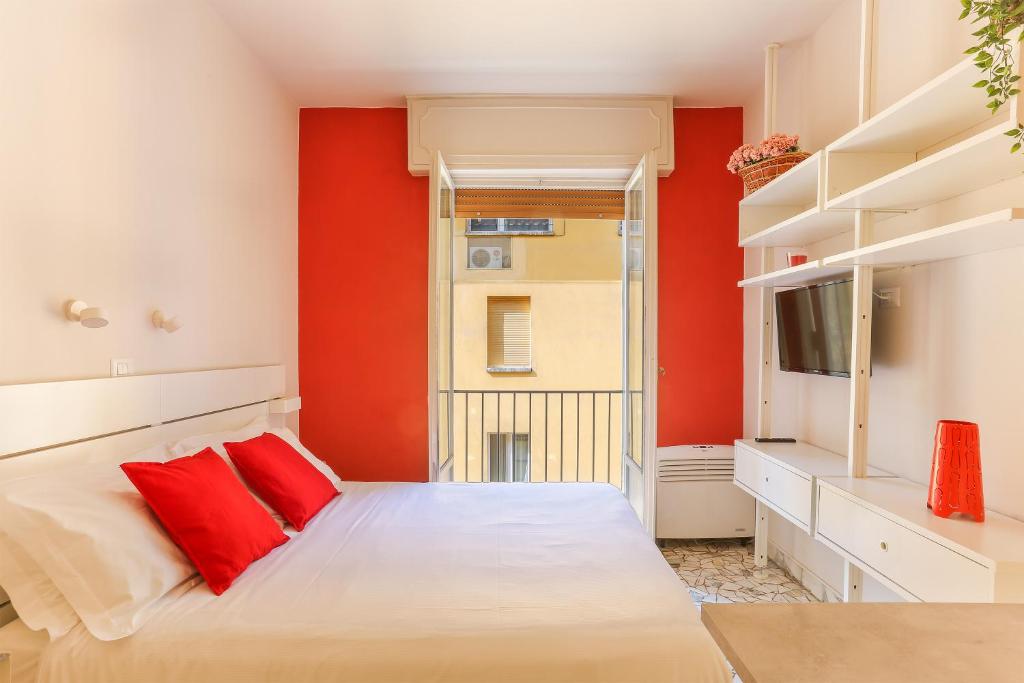 um quarto com paredes vermelhas e uma cama com almofadas vermelhas em The Red Loft in Ponte Vecchio em Florença