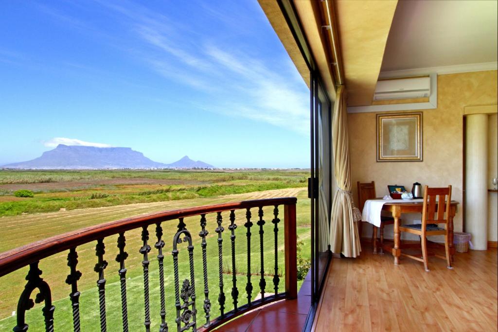 balcón con mesa y vistas al desierto en Casa Mia Guesthouse, en Table View