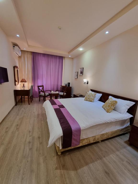 sypialnia z dużym łóżkiem i stołem w obiekcie DaMus apartments w Erywaniu