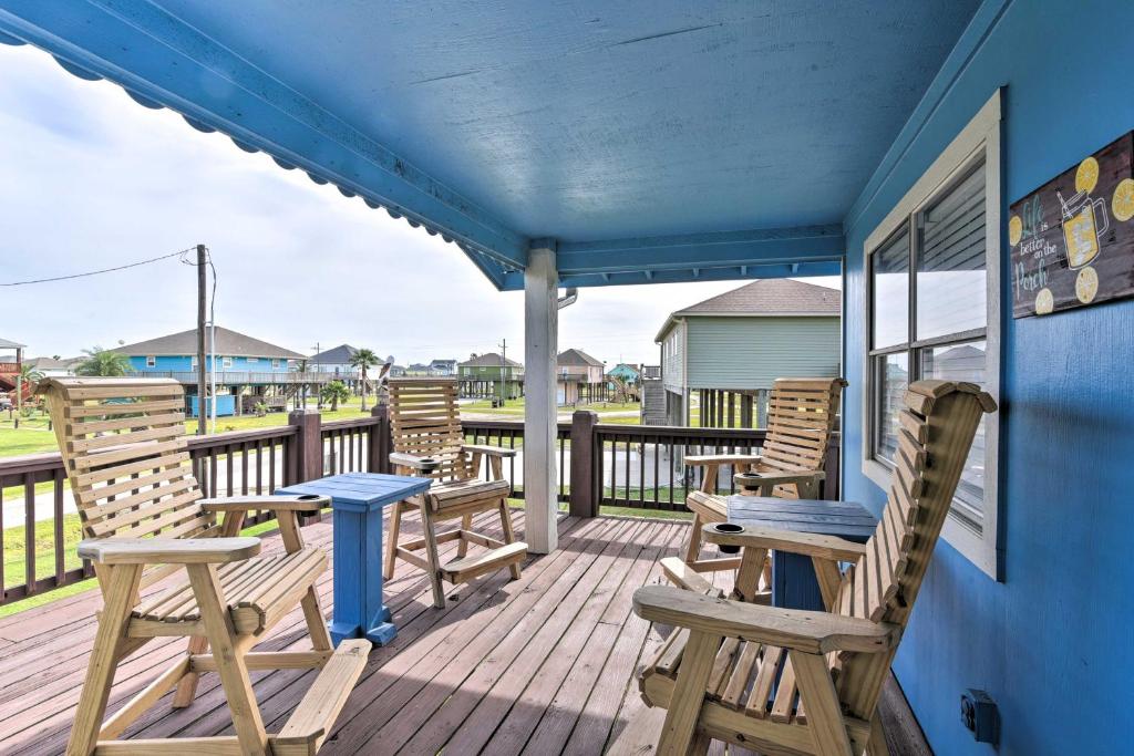a porch with wooden chairs and a blue table at Colorful Crystal Beach Home with Ocean View! in Crystal Beach