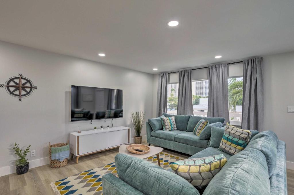 a living room with two blue couches and a tv at Cozy West Palm Beach Condo 1 Block to Shore! in West Palm Beach
