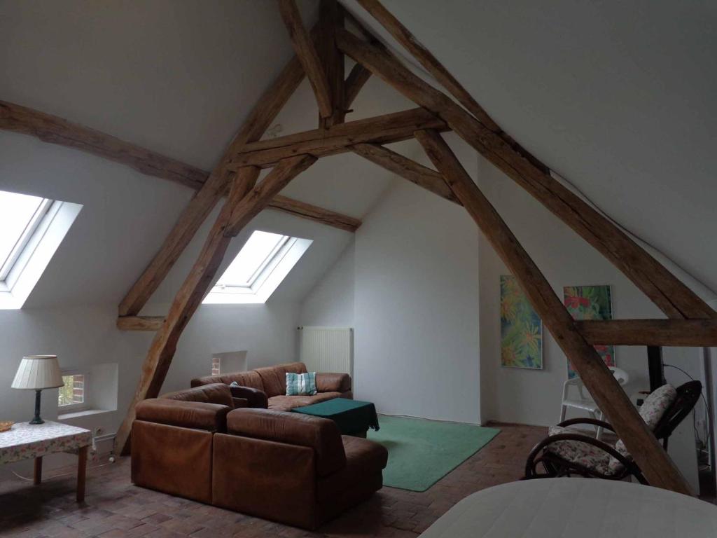 a living room with wooden beams in a attic at Charmante maison in Grand Bailly