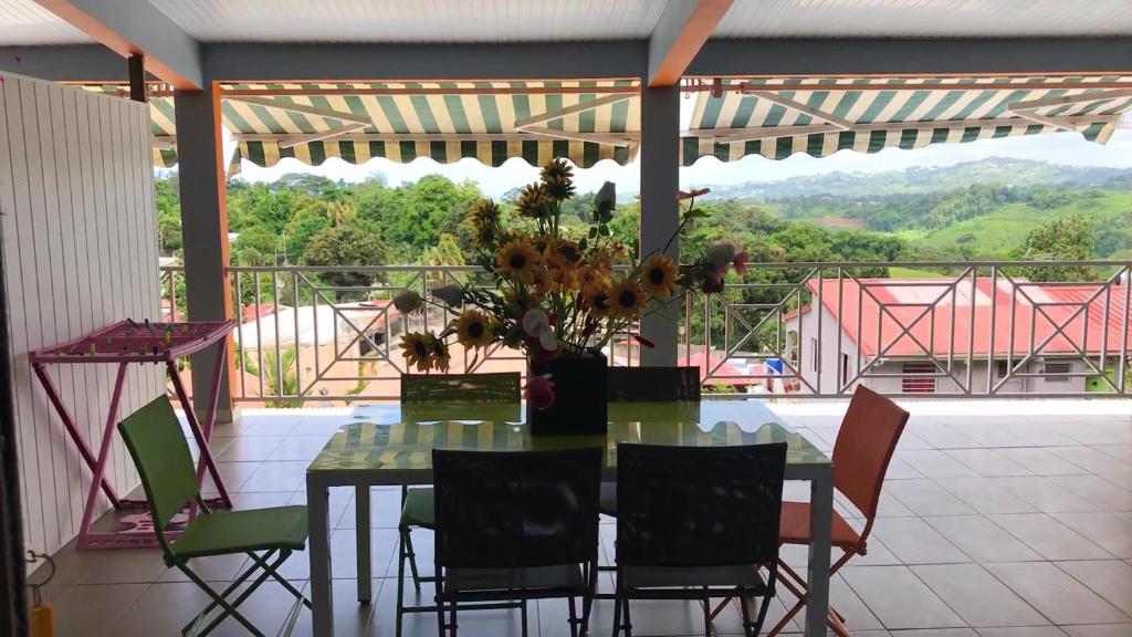 d'une table avec des chaises et un vase de fleurs sur le balcon. dans l'établissement Appartement de 2 chambres avec piscine partagee spa et terrasse a Sainte Marie, à Sainte-Marie