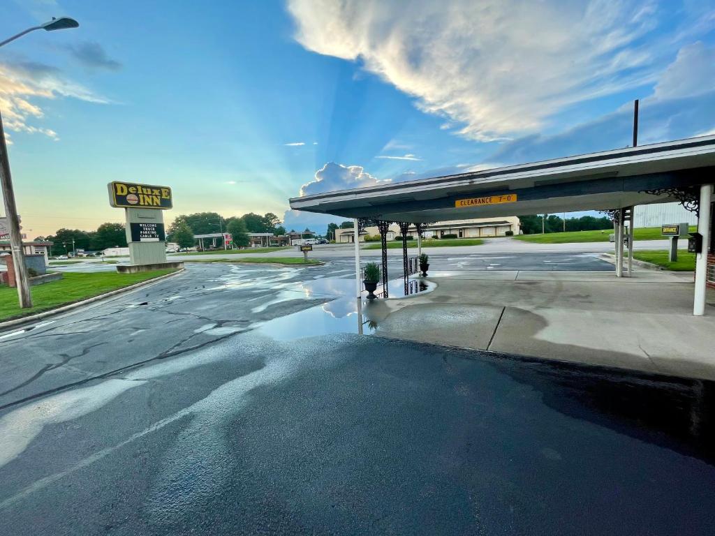 a gas station with a puddle of water on the street at Deluxe inn in Wilson