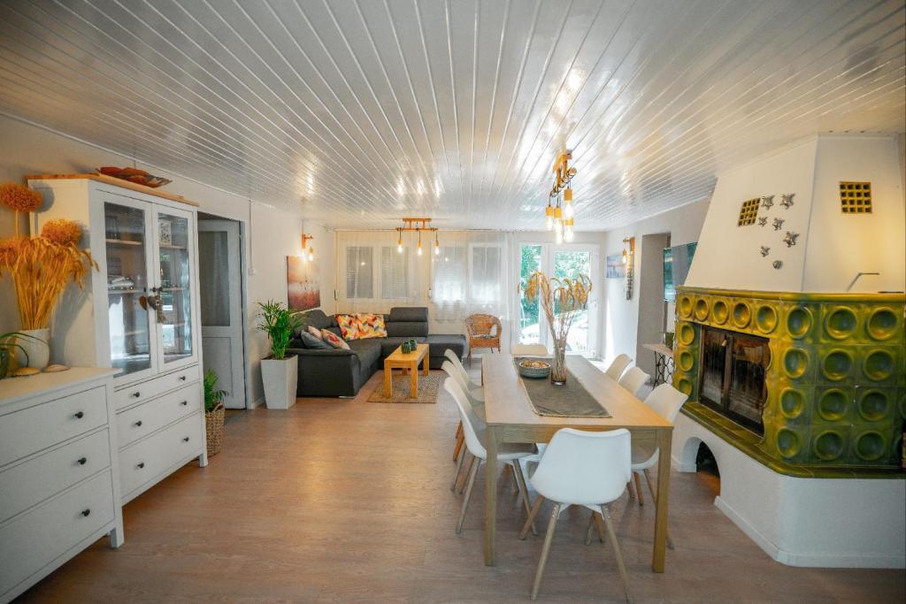 cocina y sala de estar con mesa y chimenea en Rózsa Villa Vadkerti tó, en Soltvadkert