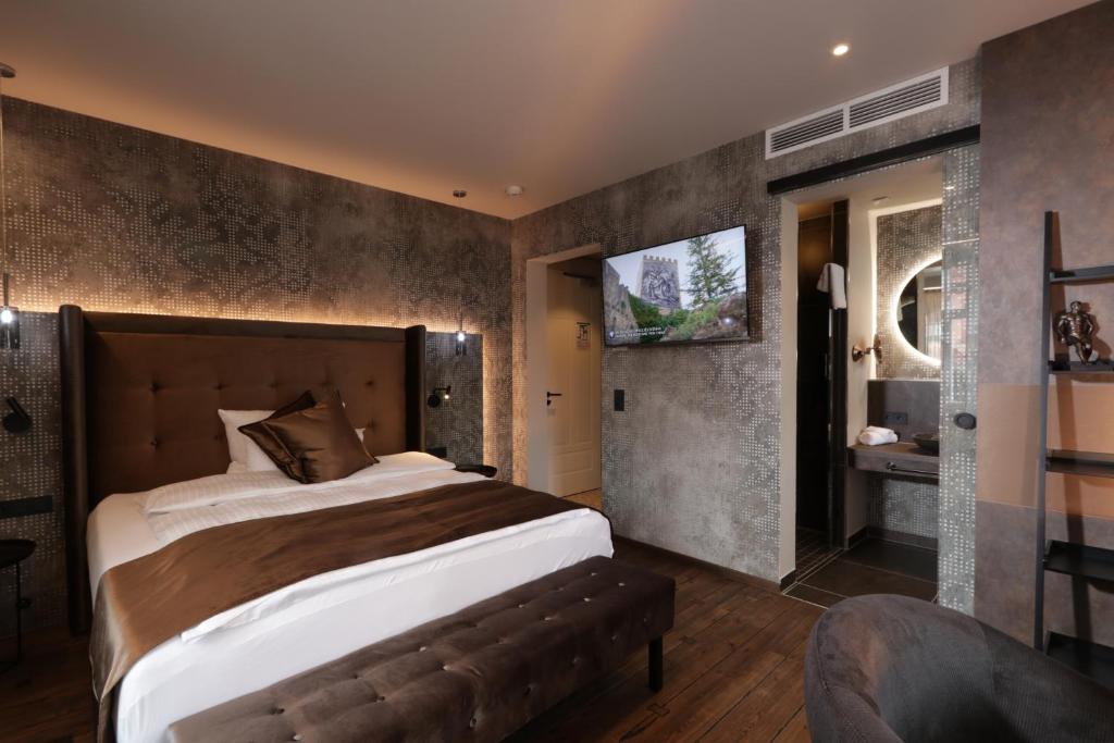 um quarto com uma cama grande e uma televisão em REINHARDTs HOTEL em Buchen