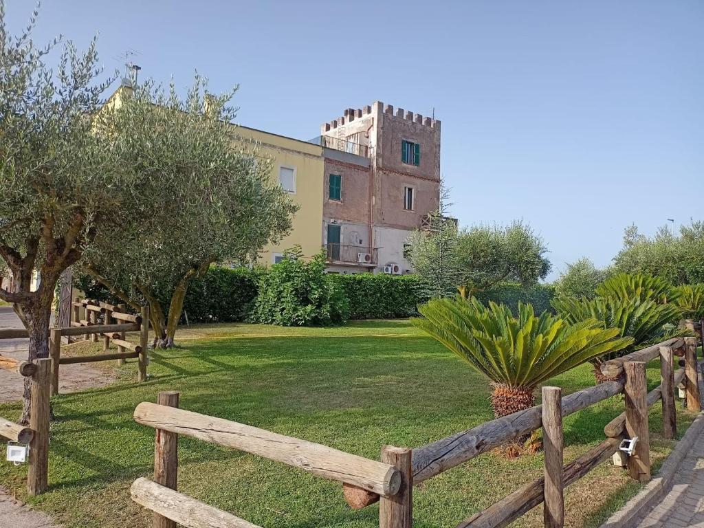 a wooden fence in a yard with a building in the background at La Torre di Barbara in Ardea