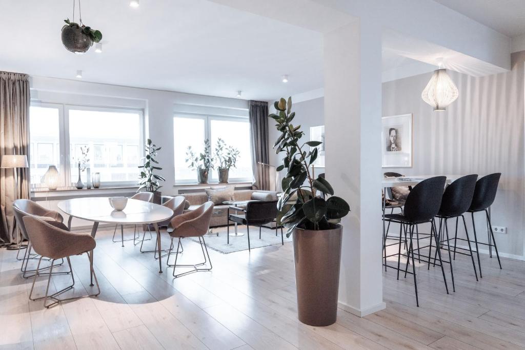 a living room with a table and chairs at Luxuriöses Loft über den Dächern Münsters 150 m² in Münster