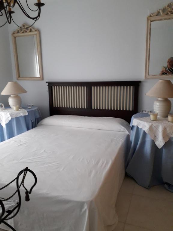 ein Schlafzimmer mit einem großen Bett mit zwei Tischen in der Unterkunft BONITAS VISTAS in Peñíscola