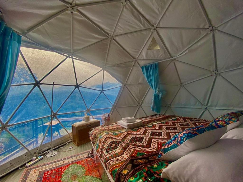 um quarto com uma cama numa cúpula de vidro em เตนท์โดมชายดอย ดอยแม่แจ๋ม ลำปาง em Ban Mai