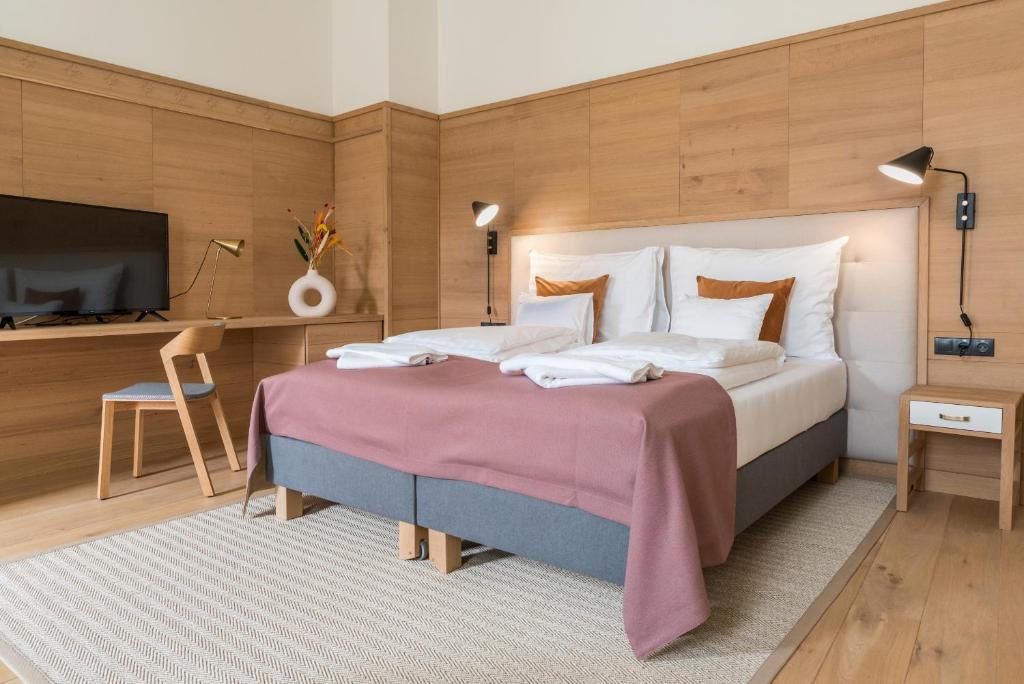a bedroom with a large bed and a flat screen tv at Isabella Boutique Hotel in Sfântu-Gheorghe