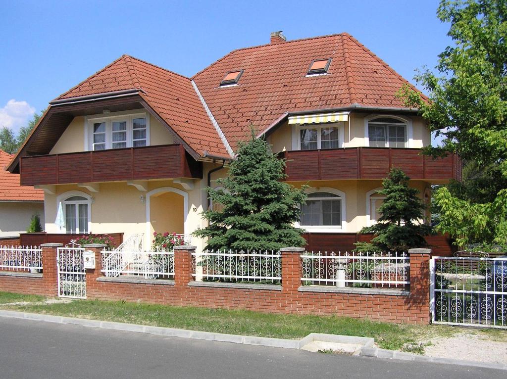 a house with a red roof and a fence at Jakab Ház in Hévíz