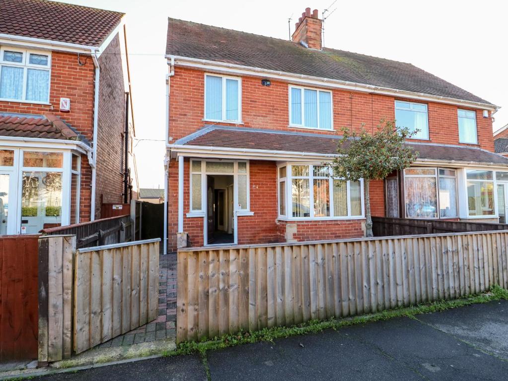 a red brick house with a wooden fence at 4 Dorothy Avenue in Skegness