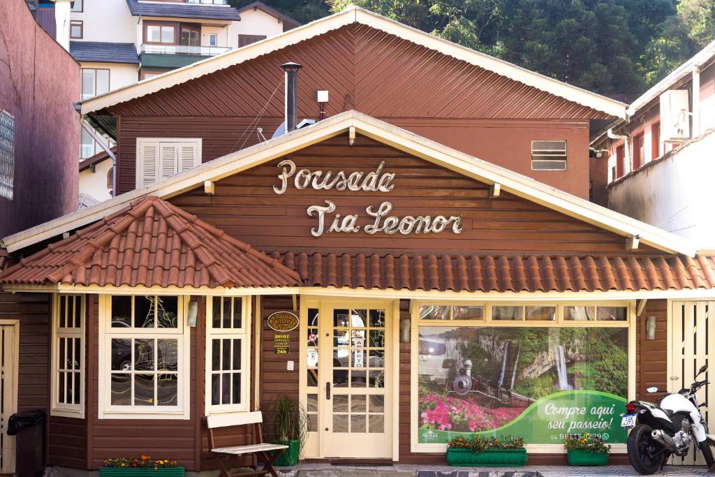 a restaurant with a sign on top of a building at Pousada Tia Leonor in Gramado