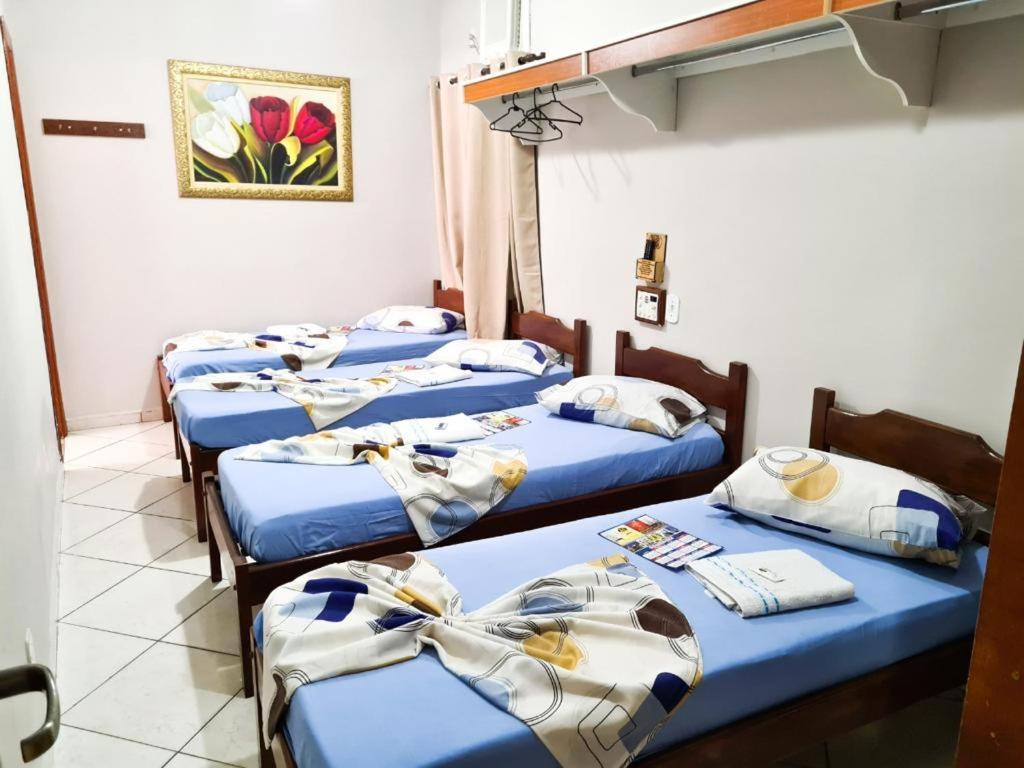 a group of four beds in a room at HOTEL OURO PRETO in Aparecida