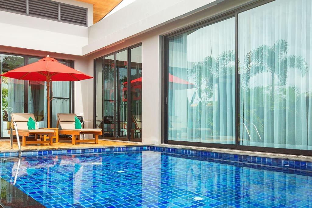 - une piscine avec une table et un parasol dans l'établissement VILLA PULAU | 2 Bedrooms Villa with Private Pool in Luxury Residence | 2 min to Naiharn Beach, à Nai Harn Beach