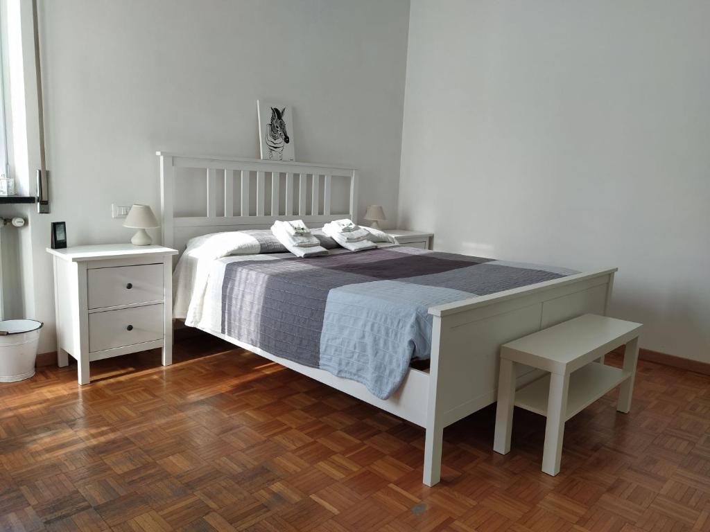 - une chambre blanche avec un lit et une table de nuit dans l'établissement Vigevano loves Milano, à Vigevano