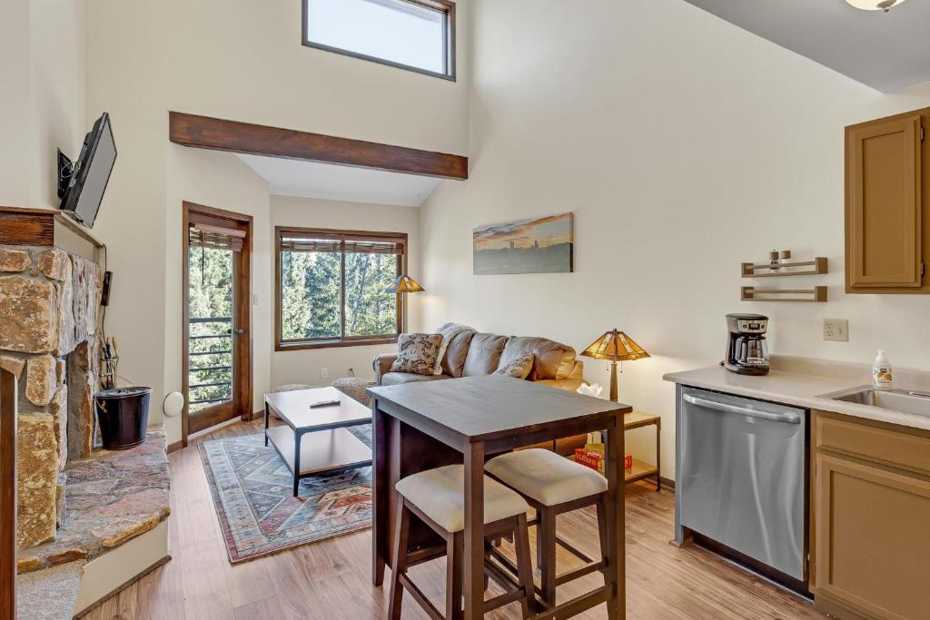 a kitchen with a table and a living room at Cozy Wildernest Loft at the top of Buffalo Mountain condo in Silverthorne