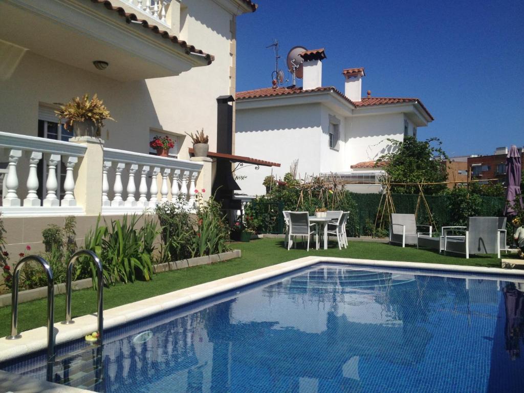 a villa with a swimming pool in front of a house at Villa Togo in Lloret de Mar