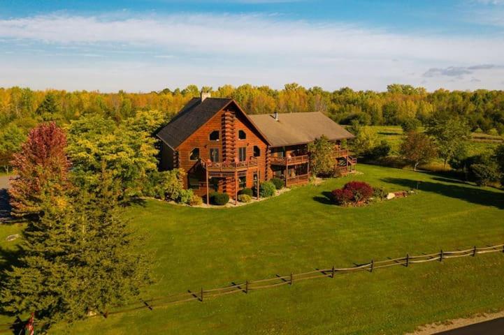 una vista aérea de una gran casa en un campo verde en Point Au Roche Lodge en Plattsburgh