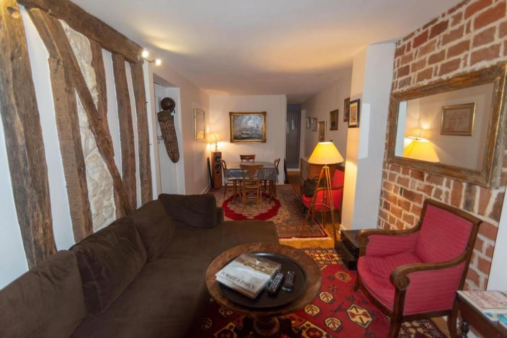 un salon avec un canapé et un mur de briques dans l'établissement Very French Two Bedroom in the Heart of Paris, à Paris