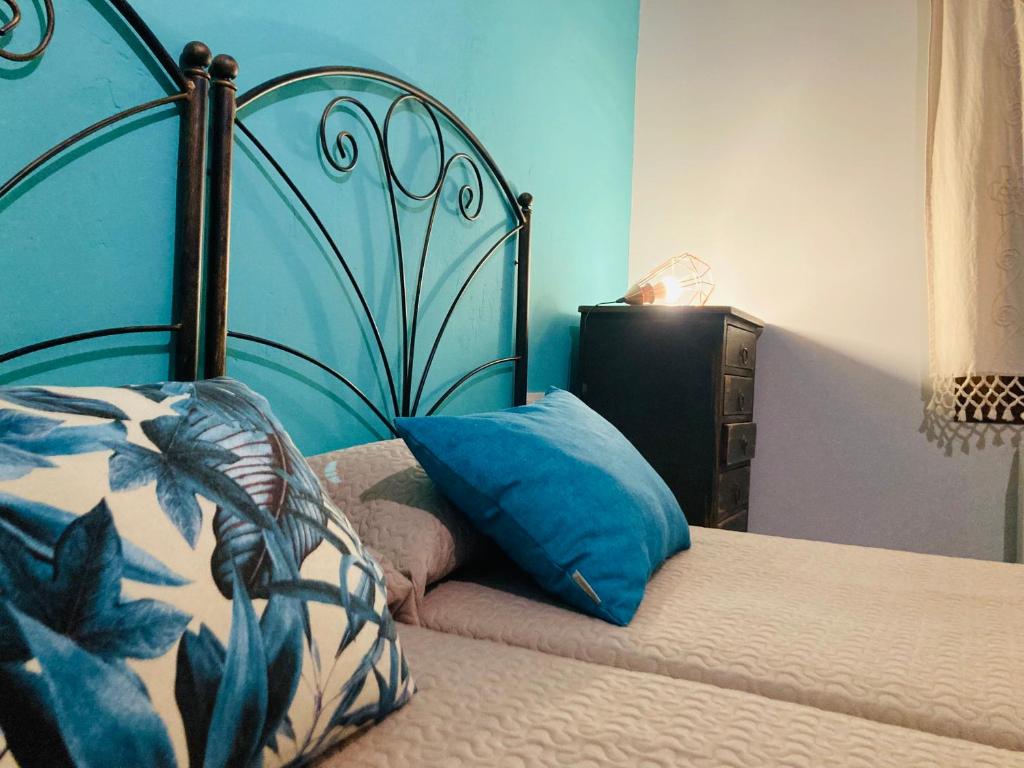 uma cama com uma cabeceira azul e uma almofada em Loteta Experience em Magallón