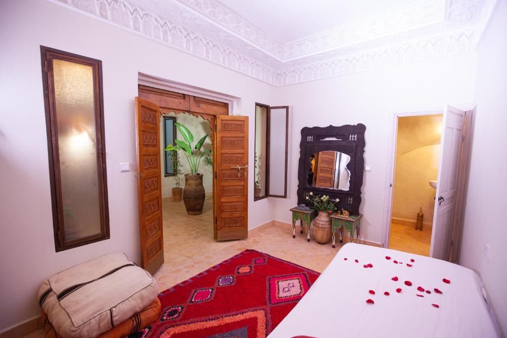Zimmer mit einem Bett und einem Zimmer mit einem Spiegel in der Unterkunft Riad Taziri in Marrakesch