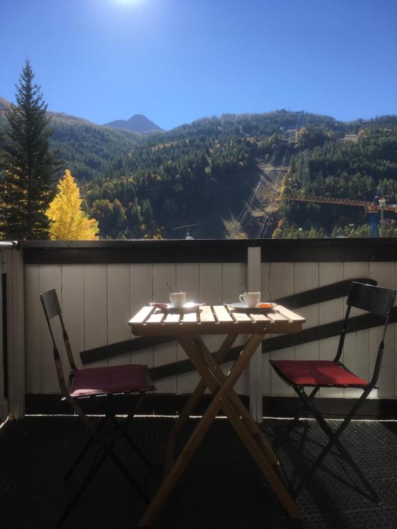 uma mesa e 2 cadeiras numa varanda com vista em Serre-Chevalier-Chantemerle. Studio Plein Sud 4per em Saint-Chaffrey